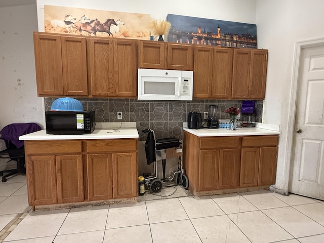 416 SE Calmoso Dr, Port Saint Lucie, FL 34983 - kitchen with white microwave, black microwave, brown cabinetry, and light countertops