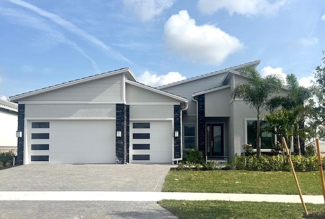 10742 Stellar Cir Unit 11, Palm Beach Gardens, FL 33412 - contemporary house with an attached garage, decorative driveway, stucco siding, and a front lawn