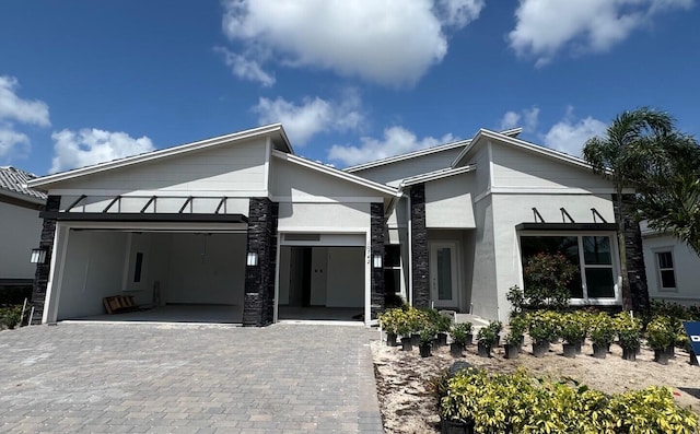 10742 Stellar Cir Unit 11, Palm Beach Gardens, FL 33412 - view of front of property with an attached garage, decorative driveway, stone siding, and stucco siding