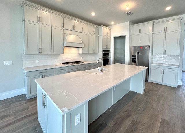 10742 Stellar Cir Unit 11, Palm Beach Gardens, FL 33412 - kitchen featuring a sink, custom exhaust hood, stainless steel appliances, a large island with sink, and decorative backsplash