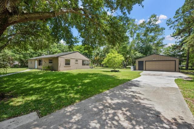 13704 58th Ct N, The Acreage, FL 33411 - view of grassy yard featuring a detached garage, an outdoor structure, and view of scattered trees
