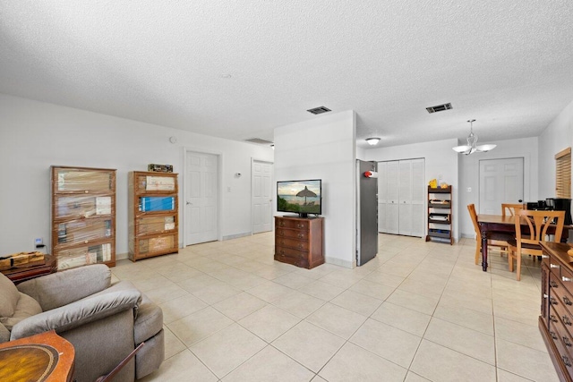 13704 58th Ct N, The Acreage, FL 33411 - living room featuring a chandelier, a textured ceiling, light tile patterned floors, and baseboards