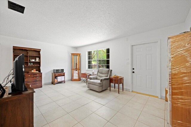 13704 58th Ct N, The Acreage, FL 33411 - living room with light tile patterned floors, a textured ceiling, and baseboards