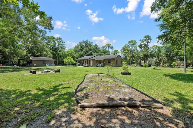 13704 58th Ct N, The Acreage, FL 33411 - view of green lawn featuring an outdoor fire pit and view of wooded area