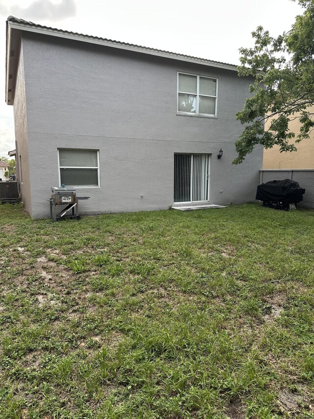6644 Country Winds Cv, Lake Worth, FL 33463 - rear view of property featuring central AC unit, stucco siding, and a yard