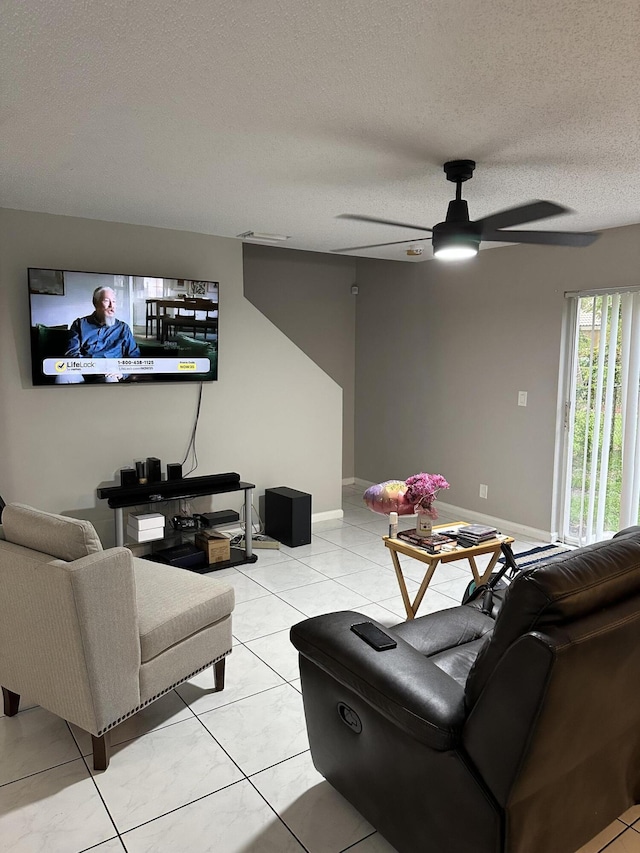 6644 Country Winds Cv, Lake Worth, FL 33463 - living room featuring ceiling fan, a textured ceiling, light tile patterned floors, and baseboards