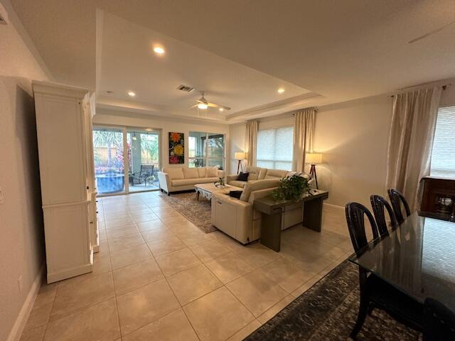 9624 SW Royal Poinciana Dr, Port Saint Lucie, FL 34987 - living room featuring baseboards, light tile patterned floors, a raised ceiling, a ceiling fan, and recessed lighting