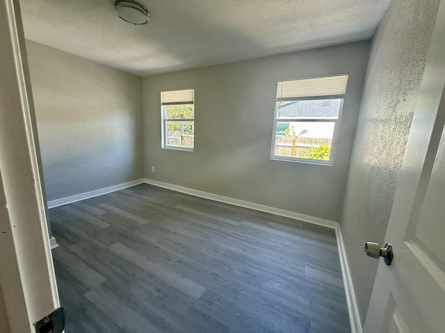 172 W 15th St, Riviera Beach, FL 33404 - spare room featuring dark wood-type flooring, baseboards, a textured ceiling, and a textured wall