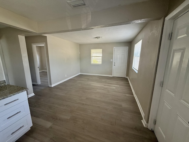 172 W 15th St, Riviera Beach, FL 33404 - unfurnished dining area with baseboards and dark wood-style flooring