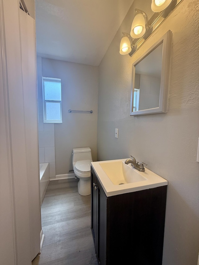 172 W 15th St, Riviera Beach, FL 33404 - bathroom featuring toilet, vanity, a bathtub, wood finished floors, and baseboards