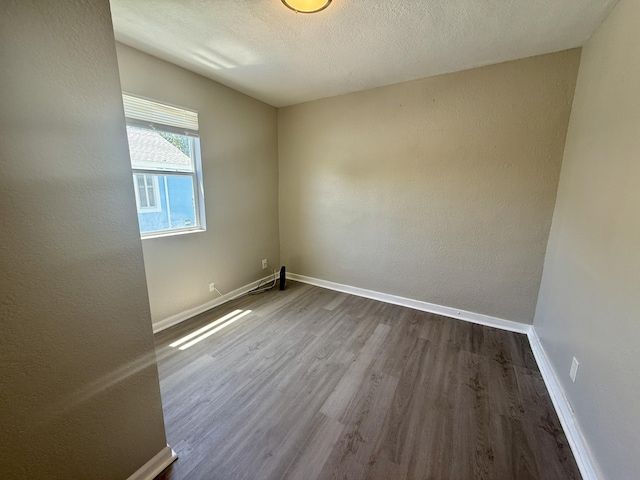 172 W 15th St, Riviera Beach, FL 33404 - unfurnished room featuring dark wood-style floors, baseboards, a textured ceiling, and a textured wall