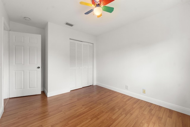 4474 Foxtail Ln, Weston, FL 33331 - unfurnished bedroom with light wood finished floors, baseboards, a closet, and ceiling fan