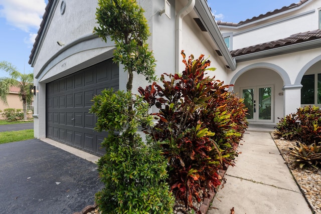 4474 Foxtail Ln, Weston, FL 33331 - view of property exterior with asphalt driveway, stucco siding, a garage, and a tile roof