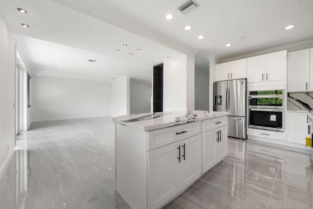 4474 Foxtail Ln, Weston, FL 33331 - kitchen featuring appliances with stainless steel finishes, recessed lighting, light stone countertops, a center island, and white cabinets