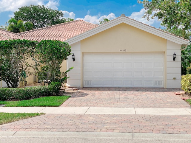 10453 SW Stratton Dr, Port Saint Lucie, FL 34987 - view of front of property featuring stucco siding, driveway, a tiled roof, and a garage