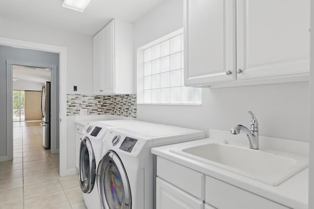 10453 SW Stratton Dr, Port Saint Lucie, FL 34987 - laundry room with washing machine and clothes dryer, cabinet space, and light tile patterned floors