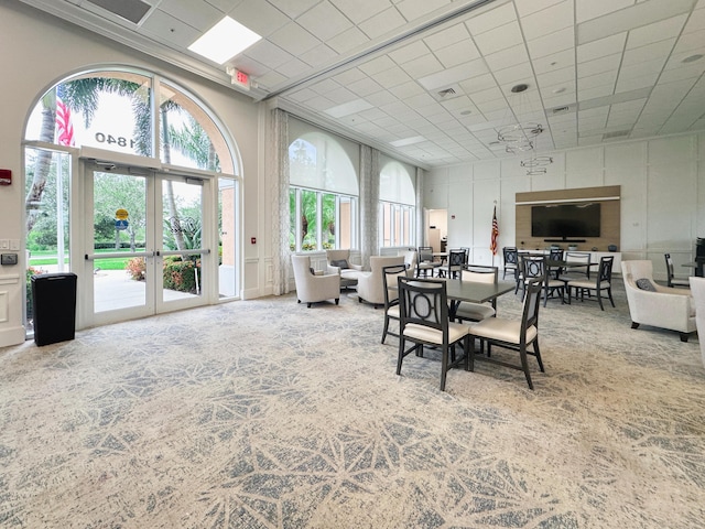 10453 SW Stratton Dr, Port Saint Lucie, FL 34987 - dining room featuring french doors, carpet flooring, and a towering ceiling