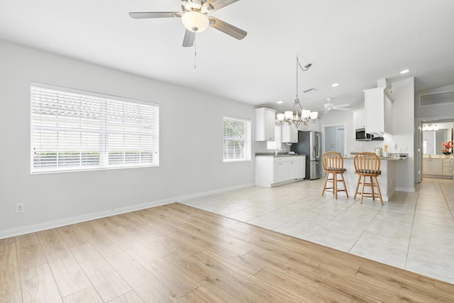 10453 SW Stratton Dr, Port Saint Lucie, FL 34987 - living area with a ceiling fan, a chandelier, baseboards, recessed lighting, and light wood-style flooring