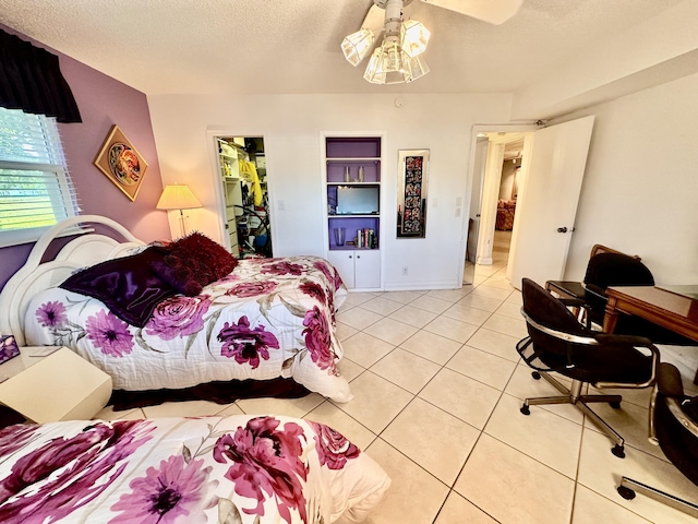 3301 Aruba Way Unit A1, Coconut Creek, FL 33066 - bedroom featuring light tile patterned flooring, a textured ceiling, a spacious closet, and a closet