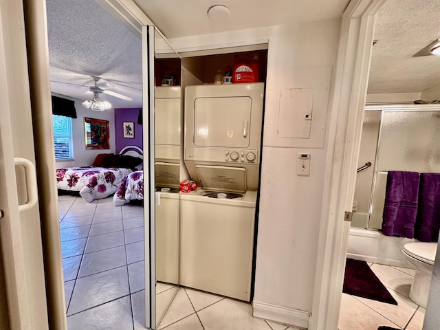 3301 Aruba Way Unit A1, Coconut Creek, FL 33066 - washroom featuring stacked washing machine and dryer, a textured ceiling, light tile patterned floors, and a ceiling fan