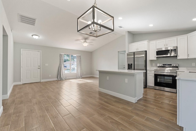 5609 Sunset Blvd, Fort Pierce, FL 34982 - kitchen with appliances with stainless steel finishes, light countertops, open floor plan, vaulted ceiling, and a chandelier