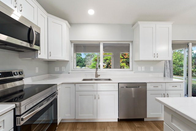 5609 Sunset Blvd, Fort Pierce, FL 34982 - kitchen with appliances with stainless steel finishes, a sink, white cabinetry, recessed lighting, and light wood-style floors