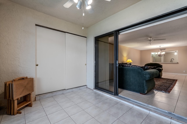 9717 Sills Dr E Unit 103, Boynton Beach, FL 33437 - living room with a ceiling fan, a textured wall, light tile patterned flooring, and a textured ceiling
