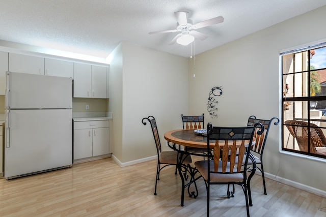 9717 Sills Dr E Unit 103, Boynton Beach, FL 33437 - dining area featuring light wood-type flooring, a ceiling fan, baseboards, and a textured ceiling