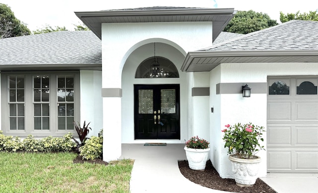2707 SE Rawlings Rd, Port Saint Lucie, FL 34952 - doorway to property featuring roof with shingles, stucco siding, and an attached garage