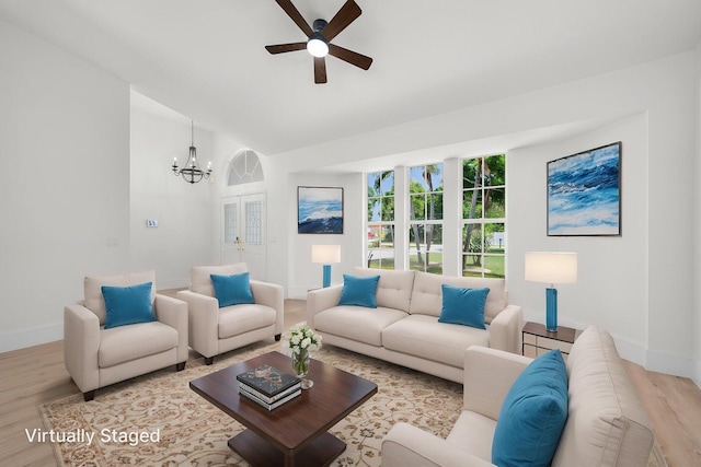 2707 SE Rawlings Rd, Port Saint Lucie, FL 34952 - living room with wood finished floors, a ceiling fan, a chandelier, baseboards, and lofted ceiling