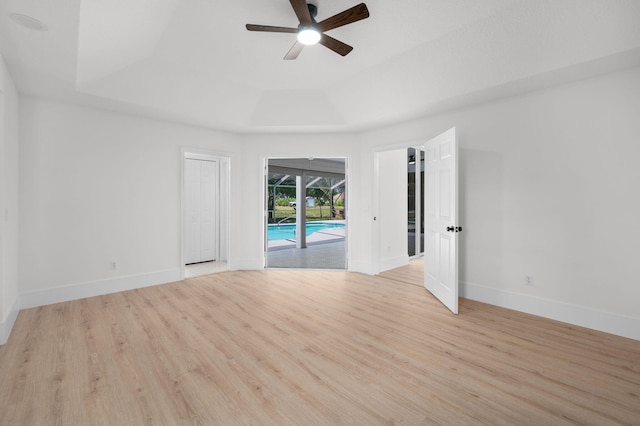 2707 SE Rawlings Rd, Port Saint Lucie, FL 34952 - spare room with a raised ceiling, a ceiling fan, light wood-style floors, and baseboards