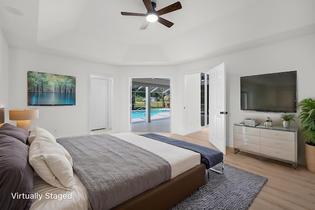 2707 SE Rawlings Rd, Port Saint Lucie, FL 34952 - bedroom with access to exterior, a tray ceiling, light wood-style floors, ceiling fan, and baseboards