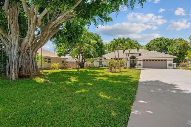 2707 SE Rawlings Rd, Port Saint Lucie, FL 34952 - view of front of property featuring an attached garage, concrete driveway, stucco siding, and a shingled roof