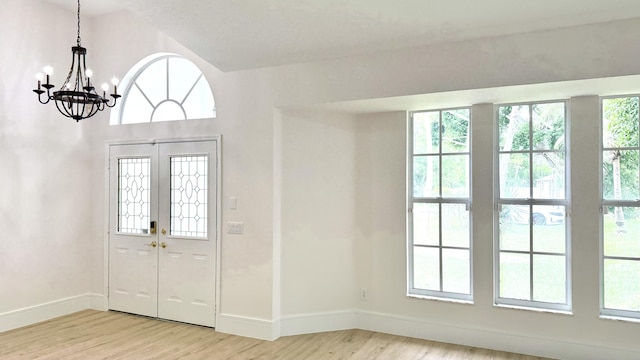 2707 SE Rawlings Rd, Port Saint Lucie, FL 34952 - entrance foyer with light wood finished floors, baseboards, and a chandelier