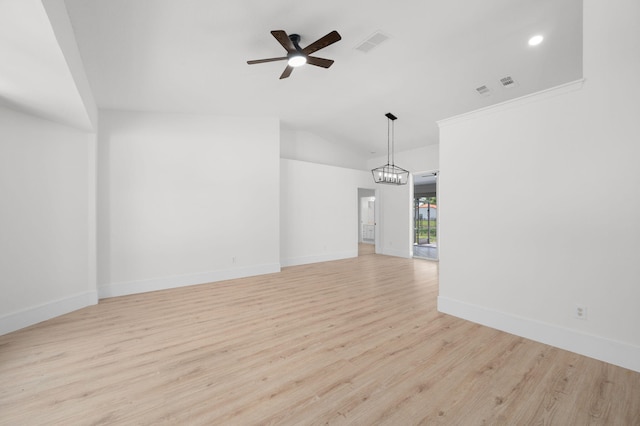 2707 SE Rawlings Rd, Port Saint Lucie, FL 34952 - empty room featuring a ceiling fan, vaulted ceiling, light wood finished floors, baseboards, and a chandelier