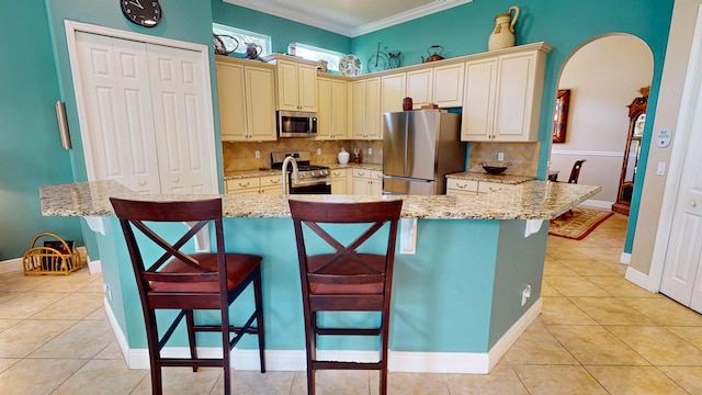 11206 SW Apple Blossom Trl, Port Saint Lucie, FL 34987 - kitchen featuring appliances with stainless steel finishes, cream cabinets, light tile patterned flooring, backsplash, and crown molding