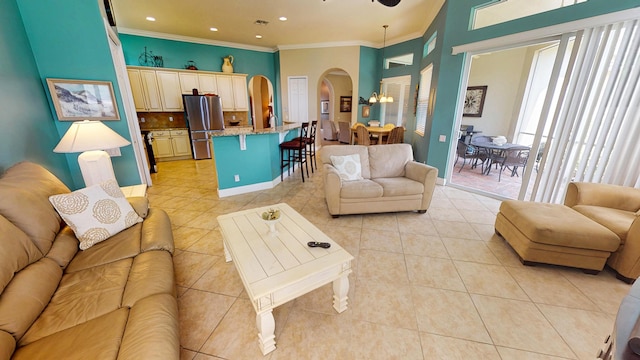 11206 SW Apple Blossom Trl, Port Saint Lucie, FL 34987 - living room featuring arched walkways, light tile patterned floors, ornamental molding, a chandelier, and baseboards