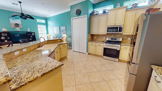11206 SW Apple Blossom Trl, Port Saint Lucie, FL 34987 - kitchen with appliances with stainless steel finishes, cream cabinetry, a sink, decorative backsplash, and crown molding
