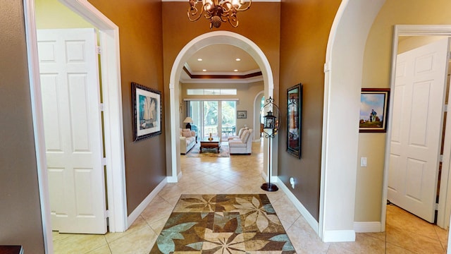 11206 SW Apple Blossom Trl, Port Saint Lucie, FL 34987 - foyer entrance featuring arched walkways, light tile patterned floors, ornamental molding, a chandelier, and baseboards
