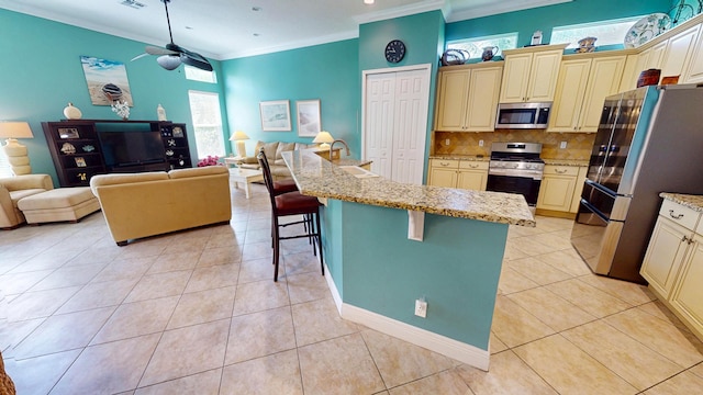 11206 SW Apple Blossom Trl, Port Saint Lucie, FL 34987 - kitchen featuring cream cabinetry, stainless steel appliances, open floor plan, crown molding, and recessed lighting