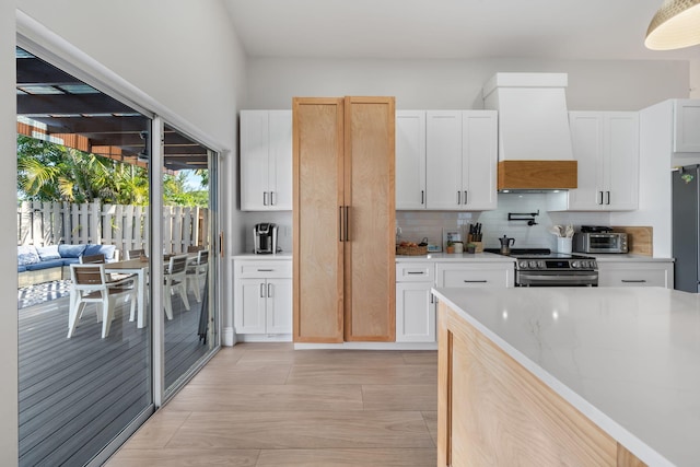 2540 NW 80th Ave, Margate, FL 33063 - kitchen with stainless steel appliances, custom exhaust hood, backsplash, and white cabinets