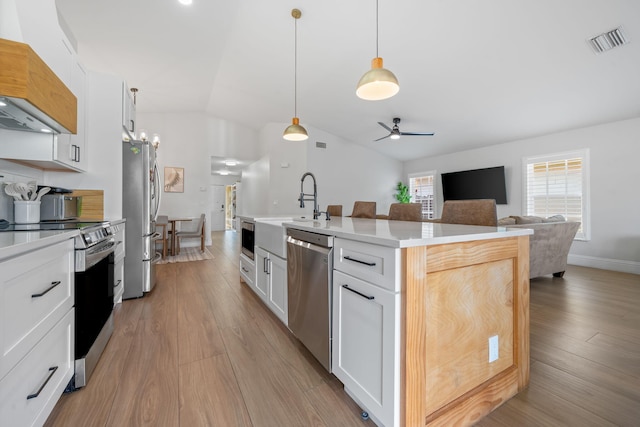 2540 NW 80th Ave, Margate, FL 33063 - kitchen with stainless steel appliances, custom exhaust hood, vaulted ceiling, white cabinets, and ceiling fan