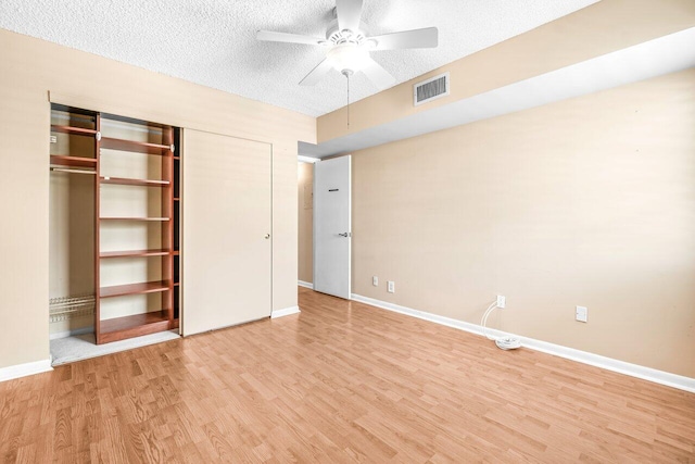 35 Capri A Unit A, Delray Beach, FL 33484 - unfurnished bedroom featuring light wood-style flooring, baseboards, a closet, ceiling fan, and a textured ceiling