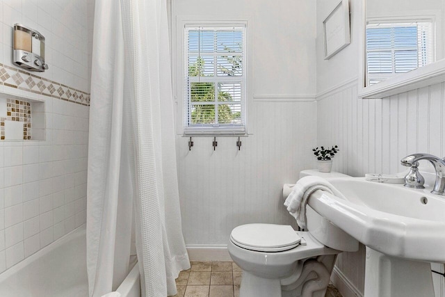 722 Valley Forge Rd, West Palm Beach, FL 33405 - bathroom with shower / tub combo with curtain, toilet, tile patterned flooring, and a wainscoted wall