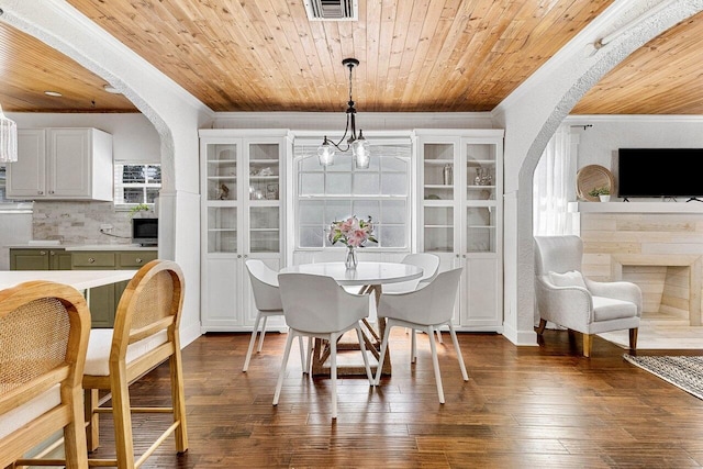 722 Valley Forge Rd, West Palm Beach, FL 33405 - dining area featuring arched walkways, crown molding, wooden ceiling, and dark wood finished floors