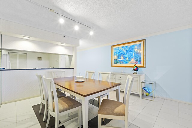 3400 S Ocean Blvd Unit 4H, Highland Beach, FL 33487 - dining room featuring a textured ceiling and track lighting