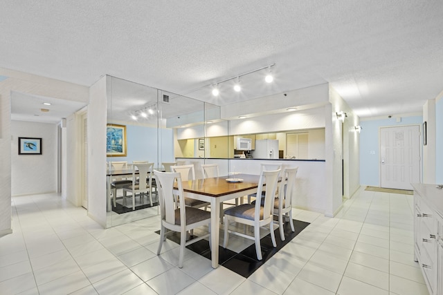 3400 S Ocean Blvd Unit 4H, Highland Beach, FL 33487 - dining area with rail lighting, light tile patterned floors, a textured ceiling, and baseboards