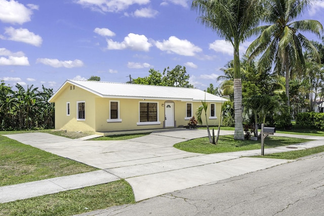 1332 SW G, Belle Glade, FL 33430 - single story home featuring concrete driveway, stucco siding, a front yard, and metal roof
