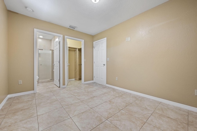 1332 SW G, Belle Glade, FL 33430 - unfurnished bedroom with light tile patterned floors, a closet, baseboards, and a walk in closet