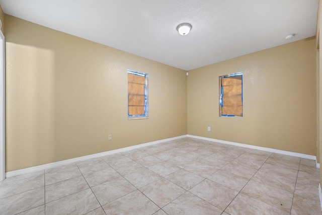 1332 SW G, Belle Glade, FL 33430 - empty room with light tile patterned flooring, a smoke detector, and baseboards